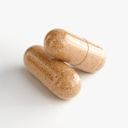 Close-up of two Jeemya Bee Pearl capsules on a white background, showing the natural-colored capsule design.