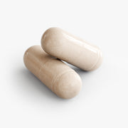 Close-up of two beige Activate Formula supplement capsules formulated to support focus, memory, cognitive performance, and mental energy.