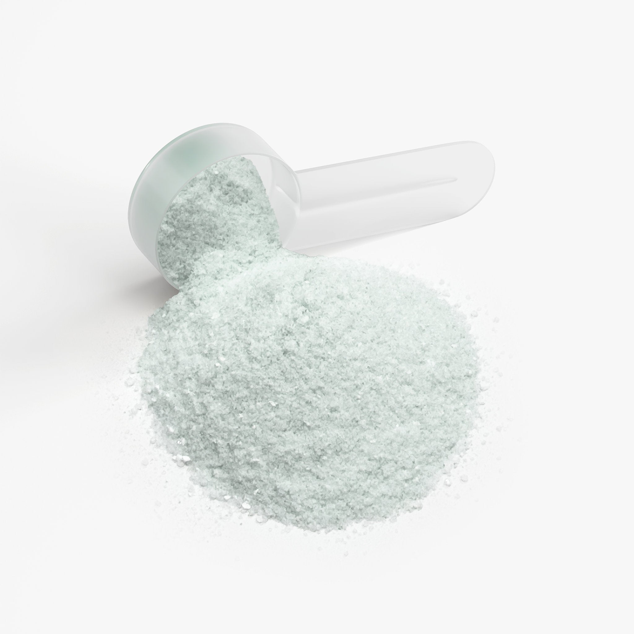 Light green Jeemya Focus Powder spilled from a white measuring scoop on a white background, highlighting the powdered supplement texture.