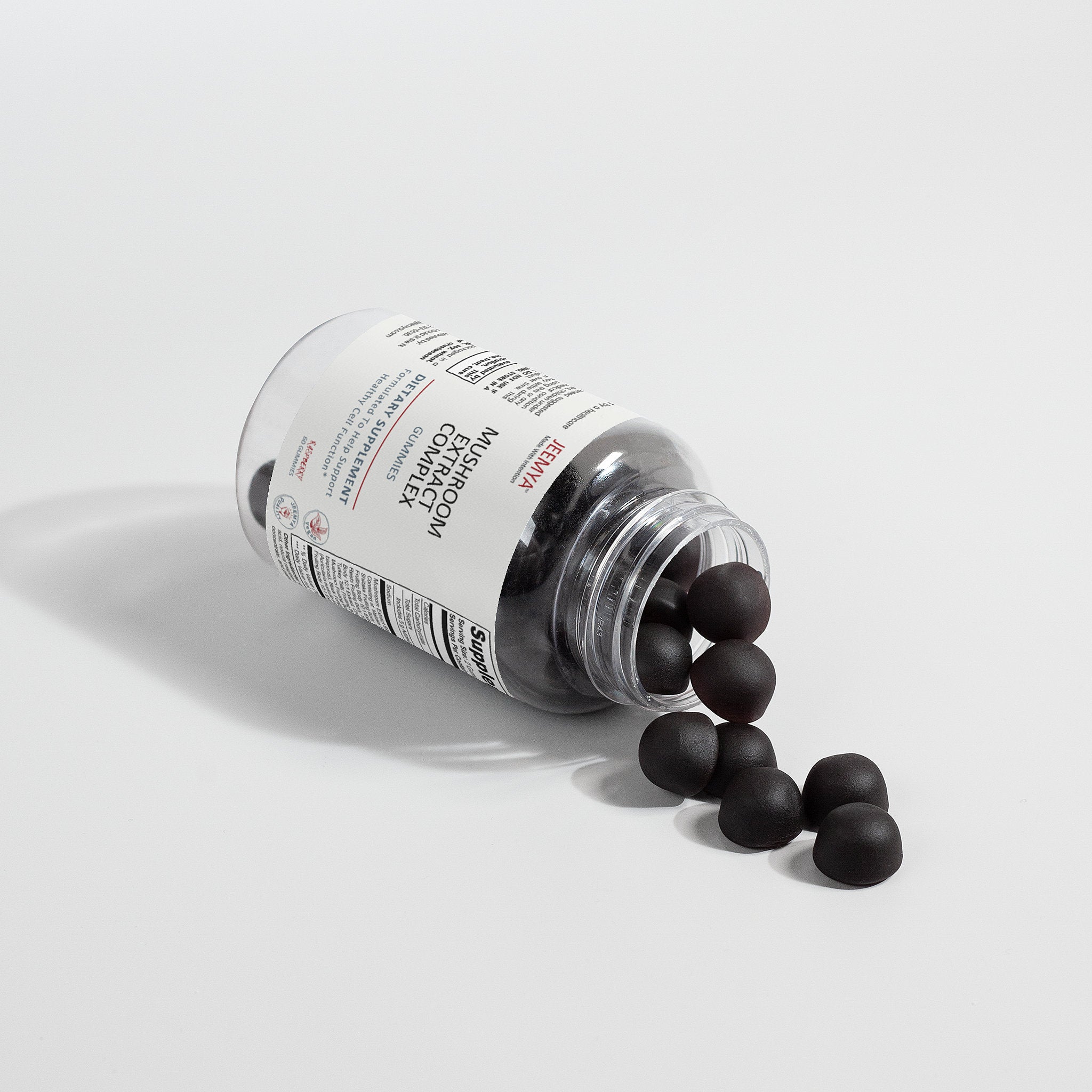Jeemya Mushroom Extract Complex gummies bottle lying on its side with dark mushroom gummies spilling onto the surface, illustrating the gummy shape, texture, and product contents.