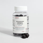 Front-facing bottle of Jeemya Mushroom Extract Complex gummies displayed with several dark mushroom gummies placed beside the bottle, showcasing the dietary supplement packaging and serving presentation.