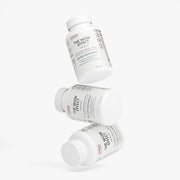 Creative arrangement of multiple Jeemya The Wow Effect supplement bottles floating at different angles, presenting the capsule packaging from multiple perspectives against a clean white background.
