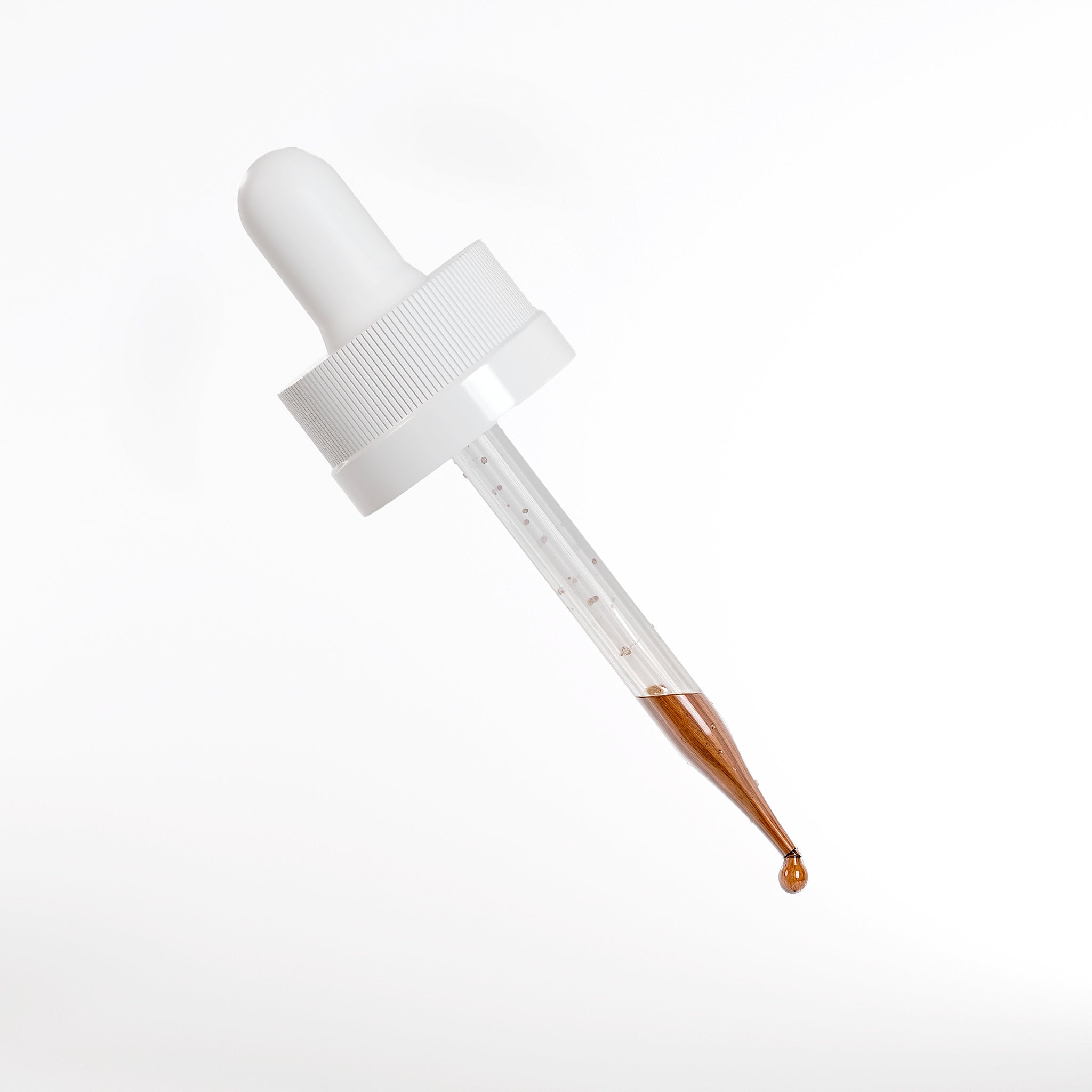 Close-up of serum dropper with peptide hair growth serum liquid designed for scalp application to support hair density, hydration, and healthy hair growth.
