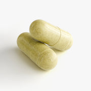 Close-up of two beige NAD+ supplement capsules containing ingredients designed to support energy production, cellular regeneration, and overall wellness.